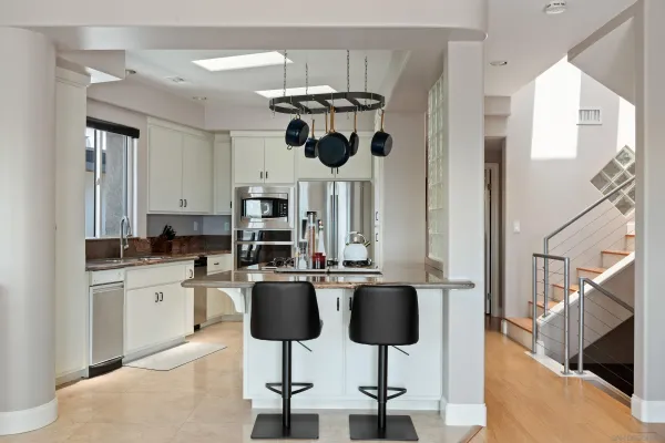 a kitchen with stainless steel appliances kitchen island granite countertop a table and chairs in it