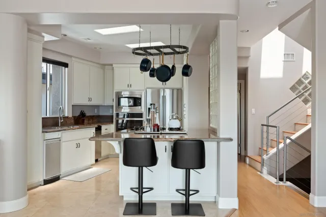 a kitchen with stainless steel appliances kitchen island granite countertop a table and chairs in it