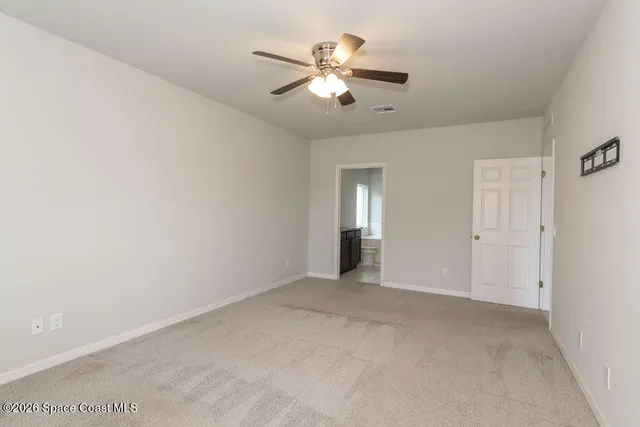 a view of an empty room with a ceiling fan