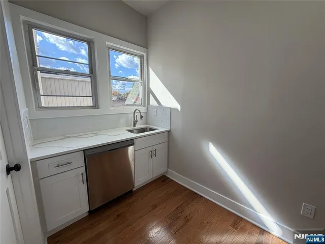 a bathroom with a granite countertop sink toilet a mirror and shower
