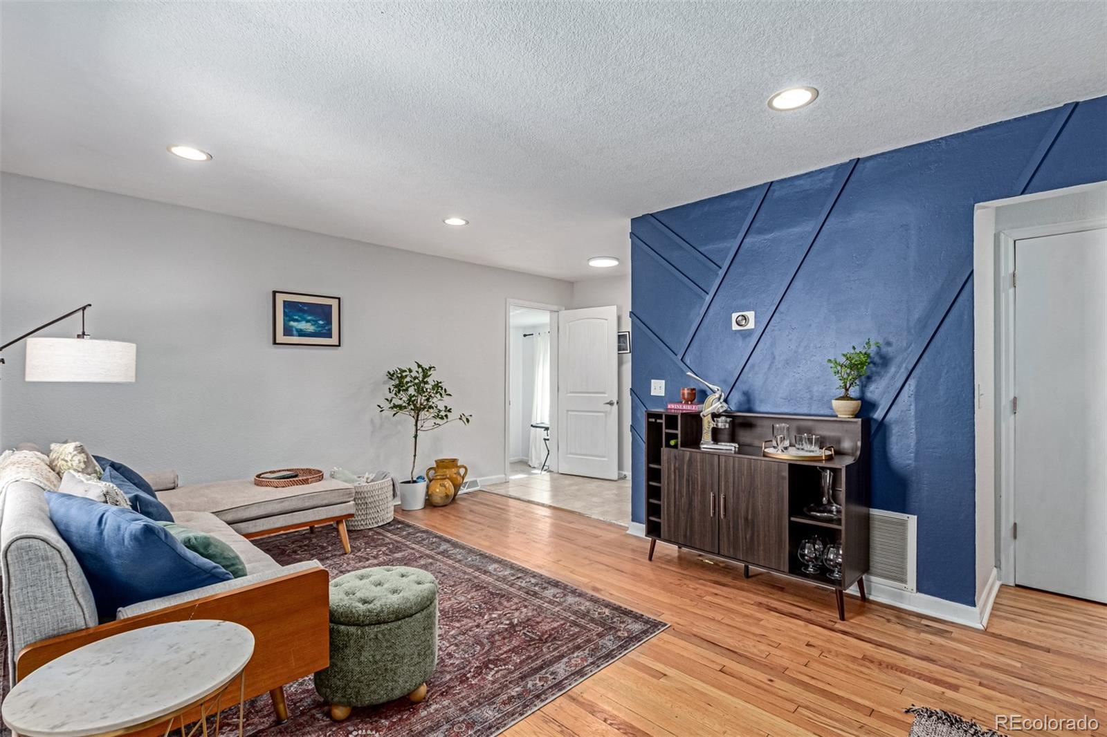 a living room with furniture and wooden floor