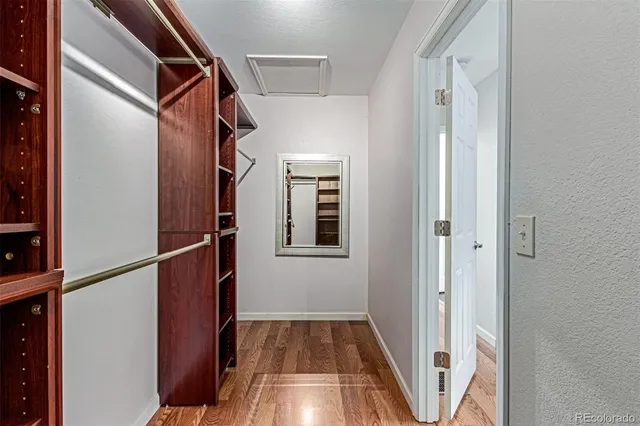 a view of walk in closet with wooden floor
