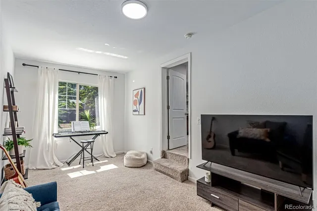 a living room with furniture a window and a flat screen tv