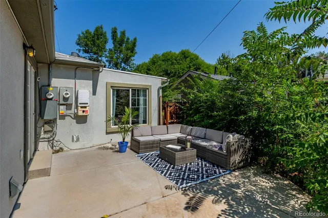 a view of a patio with couches table and chairs and potted plants