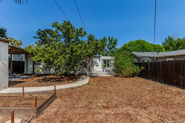 a view of a backyard with potted plants and wooden fence