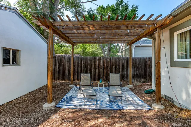 a view of a chair and table in backyard of the house