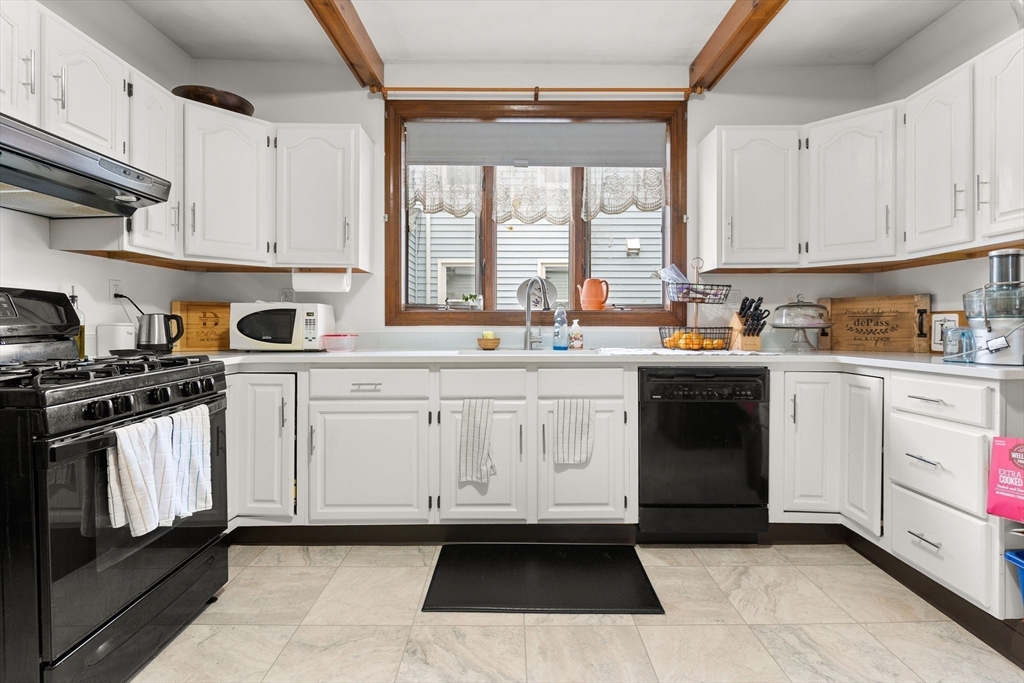 a kitchen with white cabinets sink and appliances
