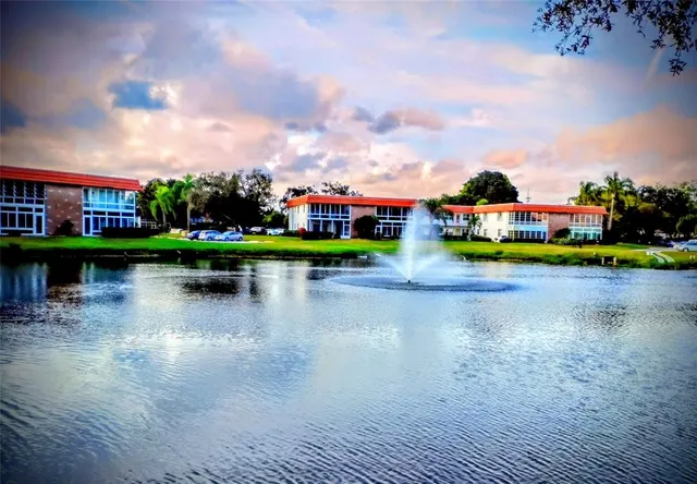 a view of swimming pool with seating space and palm tree