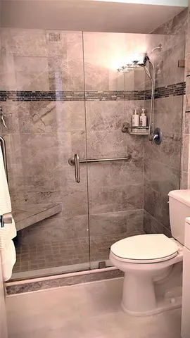 a white toilet sitting next to a shower