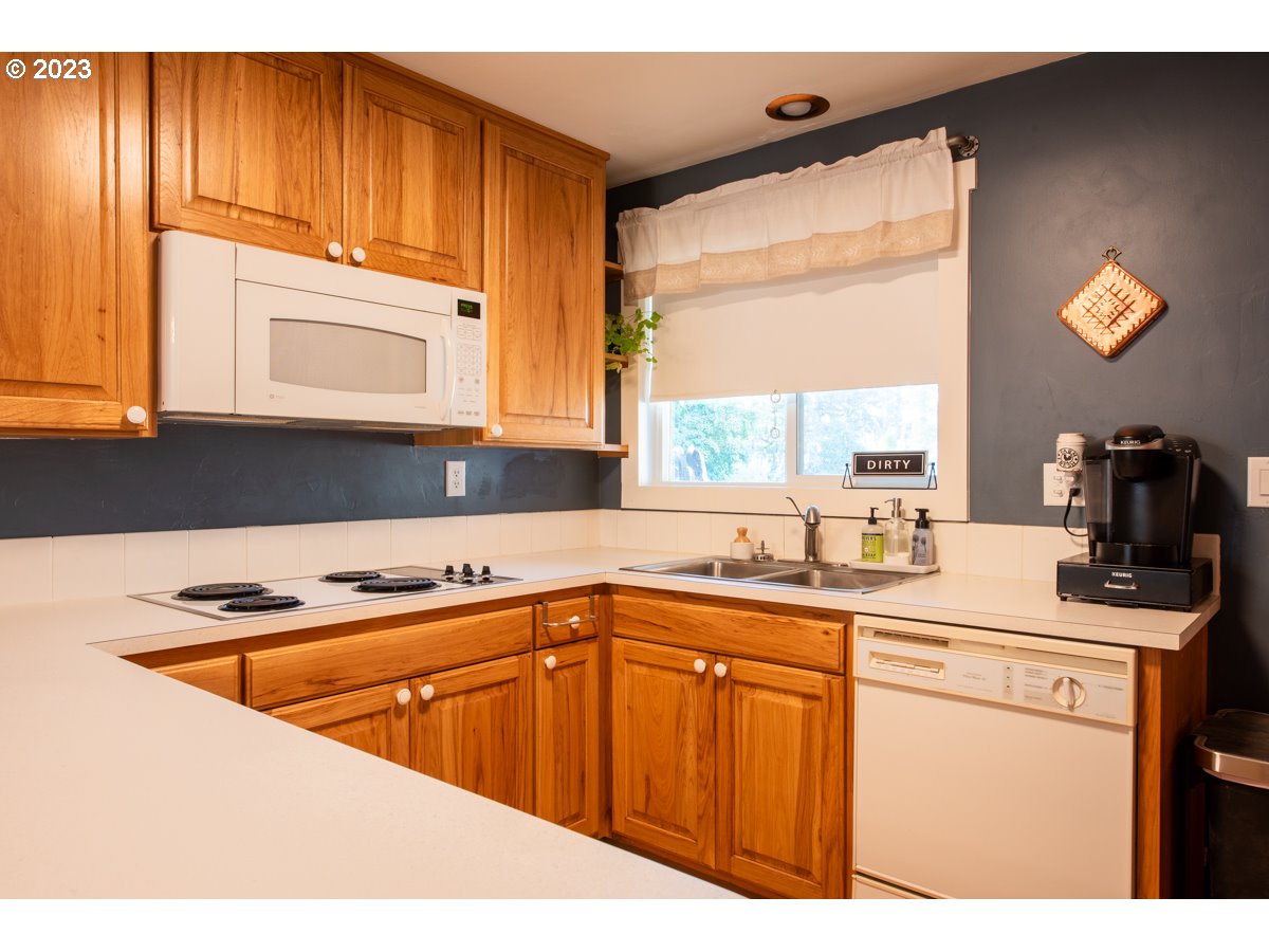 5279 Jasper Road Springfield, OR 97478 - Photo 8 of 48 a kitchen with stainless steel appliances granite countertop a sink a stove and a microwave
