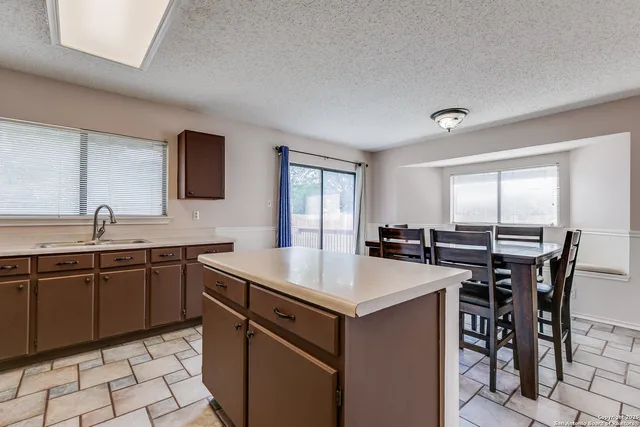 a kitchen with a sink a stove a table and chairs