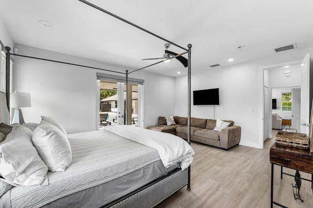 a bedroom with a bed a couch and a flat screen tv