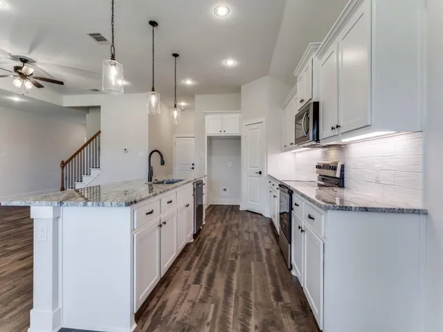 a kitchen with a sink stove and cabinets