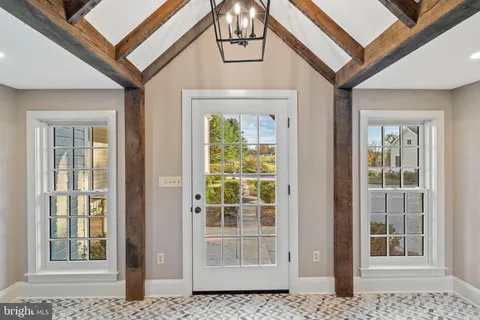a view of a dining room with furniture a chandelier and wooden floor