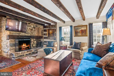 a living room with furniture fireplace and a large window