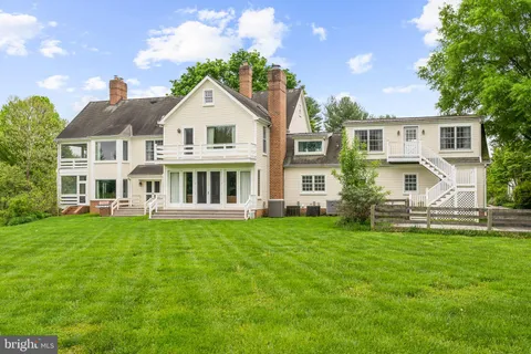 a view of a lake with a yard and large trees