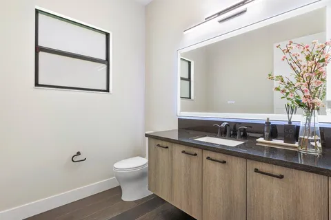 a bathroom with a granite countertop sink mirror and toilet