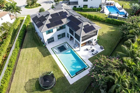 a aerial view of a house with swimming pool and outdoor seating