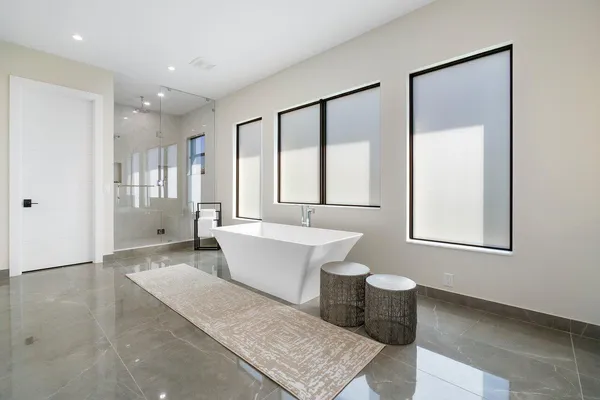 a spacious bathroom with a tub shower and mirror