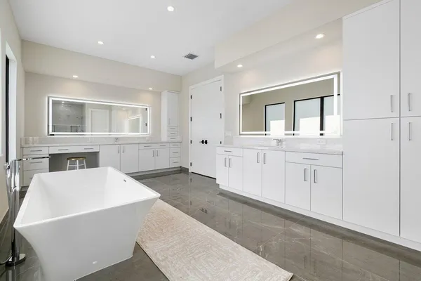 a living room with white cabinets and wooden floor