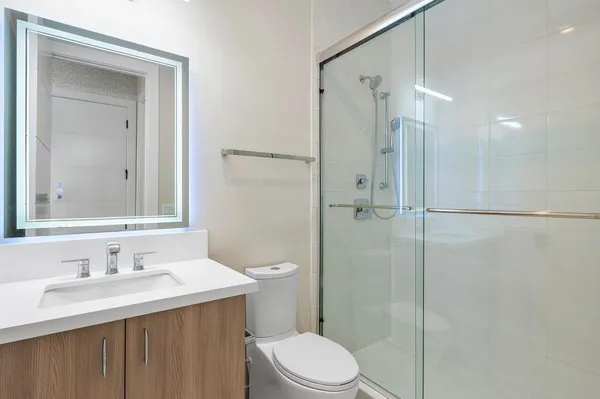 a bathroom with a sink toilet vanity and shower