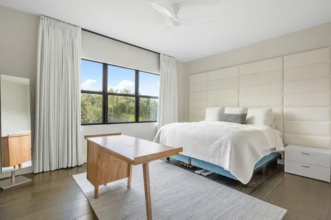 a bedroom with a bed and a large window