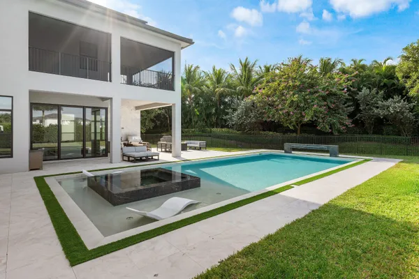a view of house with a big yard and potted plants