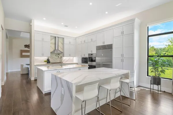 a kitchen with a table chairs refrigerator and microwave