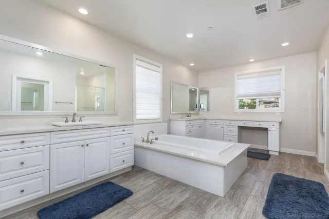 a bathroom with a double vanity sink mirror and shower