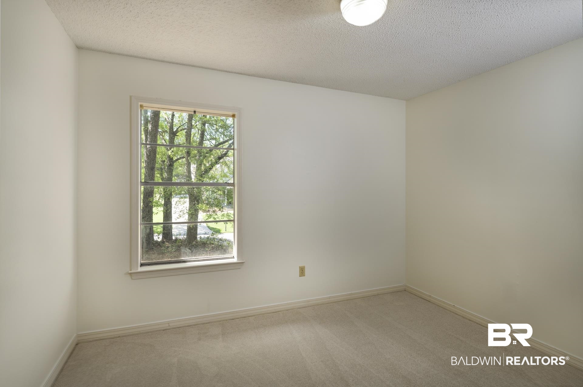 707 Johnson Avenue Fairhope, AL 36532 - Photo 26 of 38 Carpeted spare room featuring a textured ceiling and baseboards