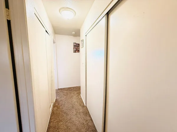 a view of a hallway with wooden floor and entryway