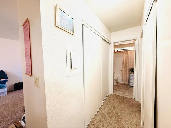 a view of a hallway with closet and bathroom