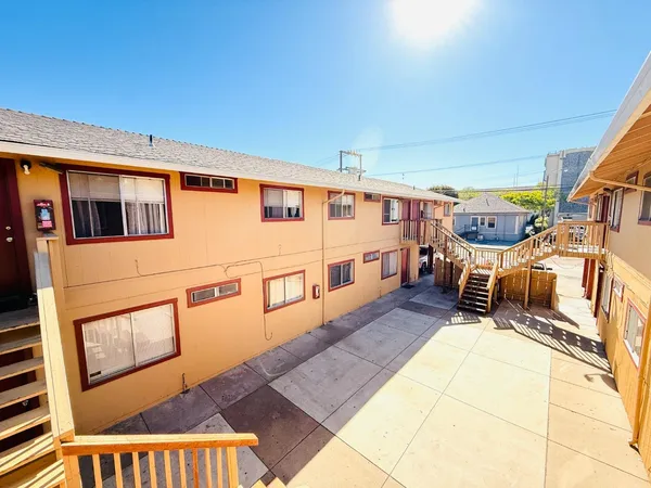 a backyard of a house with wooden floor and furniture