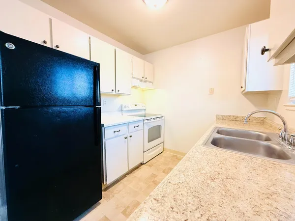 a kitchen with a sink stove and refrigerator