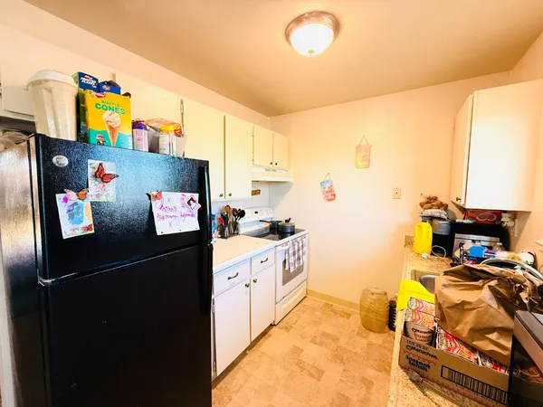 a kitchen with a refrigerator and a stove