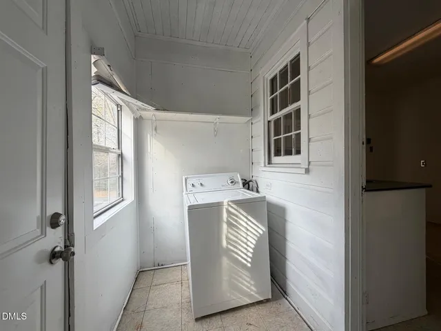 a utility room with a refrigerator and window
