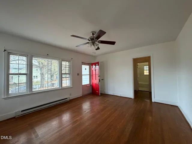 a view of a livingroom with wooden floor and a ceiling fan