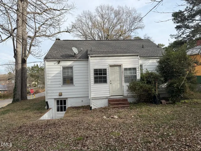 a view of a house with a yard and large tree