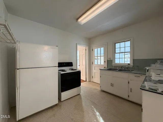 a kitchen with granite countertop a refrigerator stove a sink and dishwasher