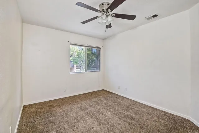 an empty room with closet and windows
