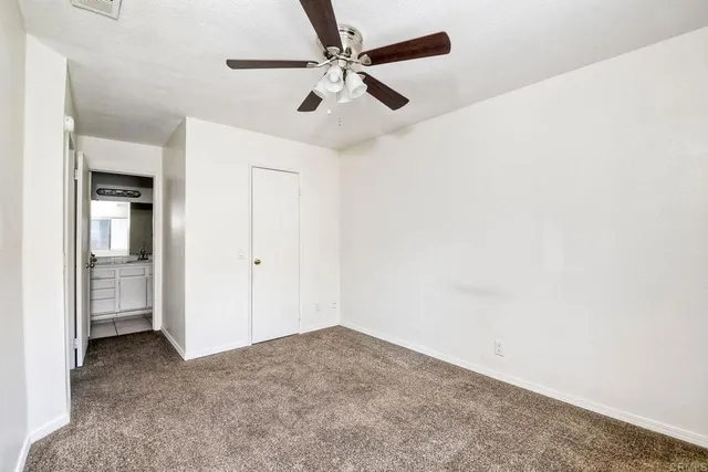 a bathroom with a granite countertop sink a toilet and shower