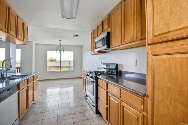 a kitchen with stainless steel appliances granite countertop a sink and a stove