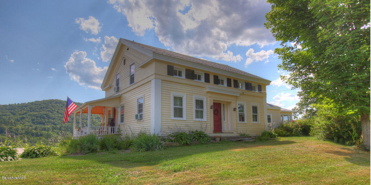 74 Main Road Tyringham, MA 01264 - Photo 1 of 2 a front view of a house with a yard and a fountain
