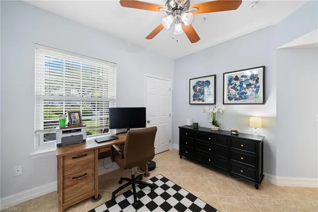 a view of a workspace with furniture and a window