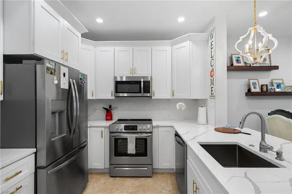 a kitchen with stainless steel appliances granite countertop a refrigerator and a sink