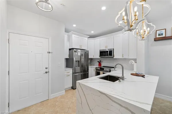 a kitchen with stainless steel appliances a refrigerator sink and microwave