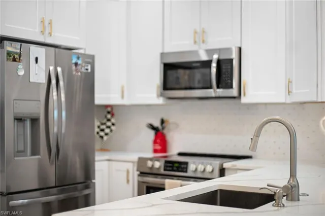 a kitchen with stainless steel appliances granite countertop a refrigerator sink and microwave