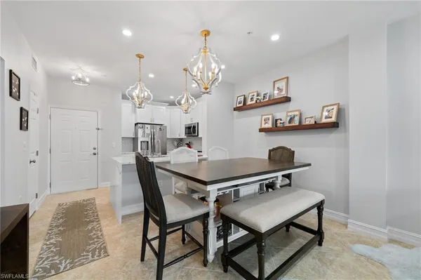 a living room with a table chairs and chandelier