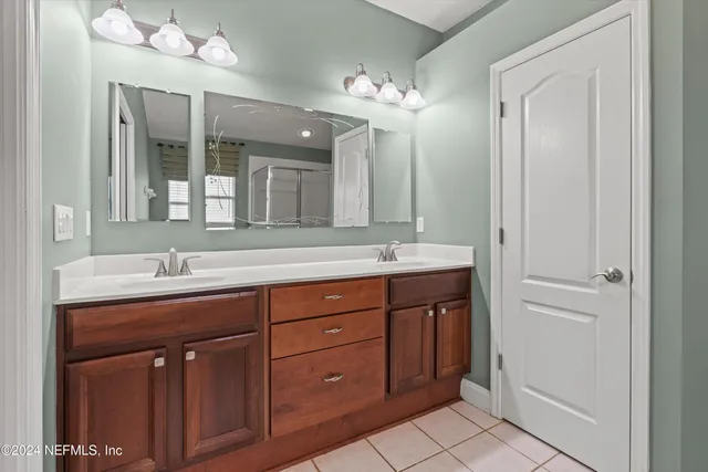 a bathroom with a double vanity sink and a mirror