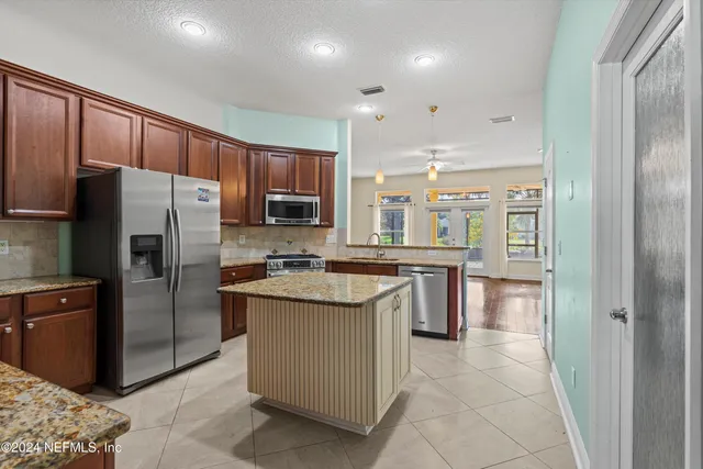 a kitchen with stainless steel appliances granite countertop a refrigerator and a stove